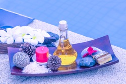 Spa Still Life With White Orchid,sea Salt,bath Oil And Candle Beside The Pool In Blue Tone.
