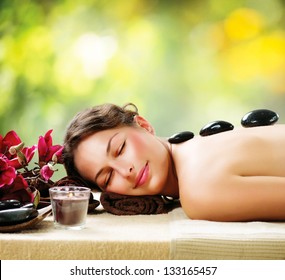 Spa Stone Massage. Beautiful Woman Getting Spa Hot Stones Massage in Spa Salon. Beauty Treatments Outdoor. Nature - Powered by Shutterstock