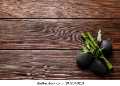 Spa Stones And Bamboo Stems On Wooden Table, Flat Lay. Space For Text