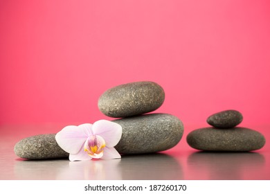 Spa Stones On Pink Background With Orchids.