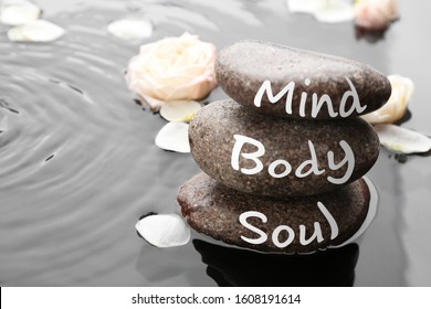 Spa stones with words Mind, Body, Soul and rose petals in water, space for text. Zen lifestyle - Shutterstock ID 1608191614