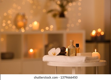Spa supplies, burning candle and flower on table in beauty salon, space for text - Shutterstock ID 1379666450