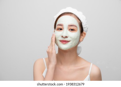 Spa Teen Asian Girl Applying Facial Clay Mask. Beauty Treatments. Over White Background.