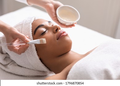 Spa therapist applying face mask on african woman skin, closeup - Shutterstock ID 1796870854
