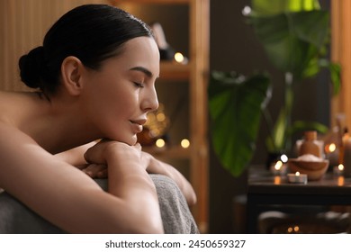 Spa therapy. Beautiful young woman lying on massage table in salon, space for text - Powered by Shutterstock