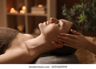 Spa therapy. Beautiful young woman lying on table during massage in salon - Powered by Shutterstock