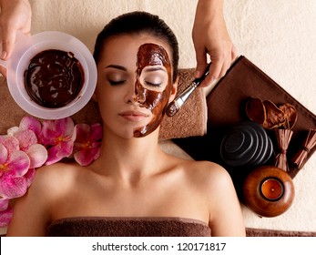 Spa therapy for young woman having cosmetic mask at beauty salon