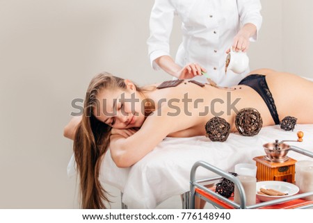 Spa therapy for young woman having cosmetic mask at beauty salon