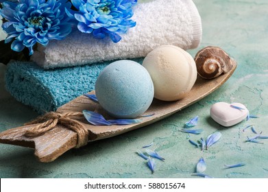 SPA treatment. Blue flowers and bath bombs on concrete background. 