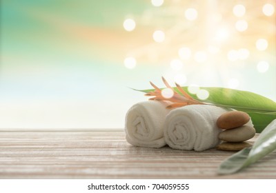 Spa Treatment Concept. Towel,massage Oil And Spa Stones With Bokeh Nature Background.
