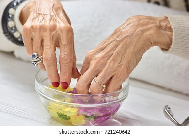 Spa Treatment For Female Hands. Old Woman Hands Having Manicure And Spa. Caucasian Woman Hands In Bowl With Water. Nail Care Concept.