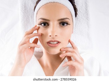 Spa and Wellness. Beautiful young woman in white bathrobe relaxing at spa salon.