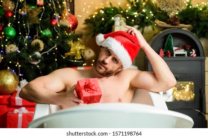 Spa And Wellness. Pampering Myself. Holidays Relax. Christmas Tour Concept. Enjoy New Years Eve Celebrations Book Stay Hotel. Man Lying In Bathtub Relax With Gift Box. Sexy Macho Relax In Bathtub.