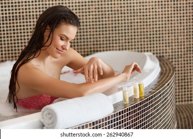 Spa Woman. Beautiful Woman In Bath Cares About Her Hands. Body Care.