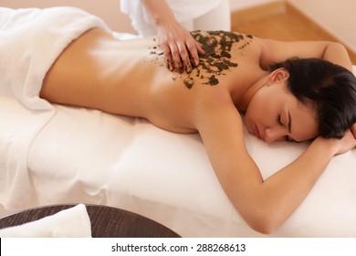 Spa Woman. Brunette Getting A Marine Algae Wrap Treatment In Spa Salon