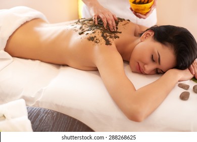 Spa Woman. Brunette Getting A Marine Algae Wrap Treatment In Spa Salon