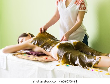 Spa Wrap With Laminaria. Woman On Seaweed Wrap At A Spa Salon. Spa Wrap With Algae. Firming Procedure.