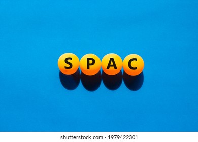 SPAC, Special Purpose Acquisition Company Symbol. Orange Table Tennis Balls With The Word 'SPAC, Special Purpose Acquisition Company'. Beautiful Blue Background, Copy Space. Medical, SPAC Concept.