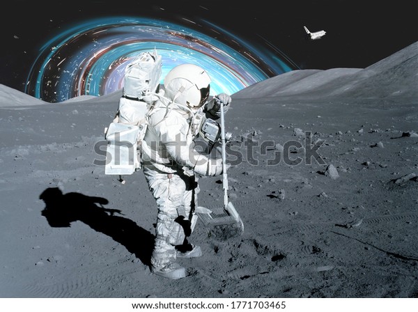 Space astronaut on the moon\
surface take soil samples with a shovel with black hole on the\
background. Soft focus. Elements of this image were furnished by\
NASA.