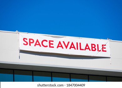 Space Available large banner sign on vacant commercial office building facade advertising the real estate, property, office for sale, rent or lease.