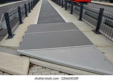 The Space Between The Lanes Of The Highway Bridge Is Blocked By A Grid. The Guardrails Are In Combination With The Black Metal Railing Bolted To The Concrete Bridge, Tension Rod