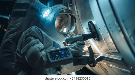 Space Engineer Servicing a Panel on a Communication Satellite with an Automatic Screw Gun. Brave Female Astronaut Working in Outer Space with Beautiful Blue Planet Earth in the Background