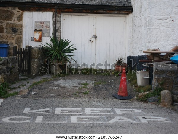 Space with keep clear written on it in car park\
next to house and garage