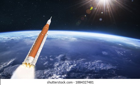 Space launch system rocket in outer space over Earth planet. SLS spaceship. Orbit of planet. Deep space expedition. Elements of this image furnished by NASA. - Powered by Shutterstock