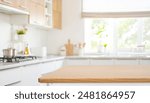 Space for product montage on wooden table top over blurred kitchen counter interior background