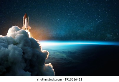 Space rocket lift off into cosmos with smoke and blast on a background of the blue planet earth. Spacecraft flies in space with a starry sky near the planet. Successful start of the mission - Powered by Shutterstock