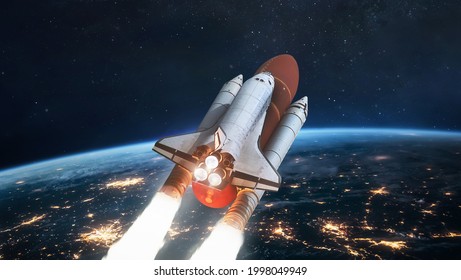 Space shuttle in space near Earth planet at night. Spaceship on orbit. View from international space station. Expedition on ISS. Elements of this image furnished by NASA - Powered by Shutterstock