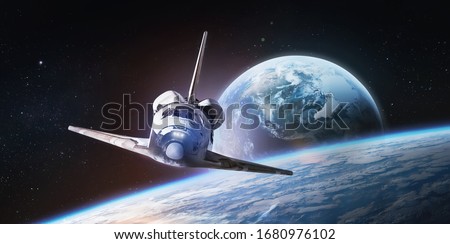 Space shuttle on orbit of the Earth planet. Spaceship. View from ISS. Elements of this image furnished by NASA.