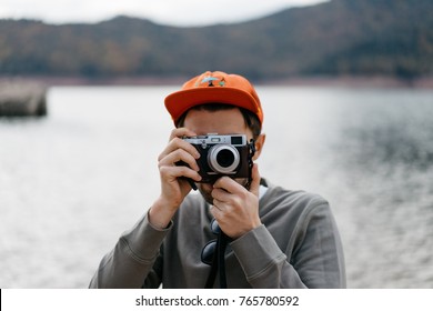 space for text, logo attractive hipster guy holding photo camera. handsome traveler shooting outdoor. mock up, young man taking pictures in the nature