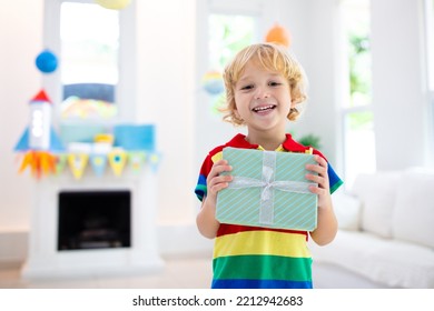 Space theme kids birthday party. Boy with present. Children celebration with astronaut, rocket, planets of solar system decoration. Family festive event. - Shutterstock ID 2212942683