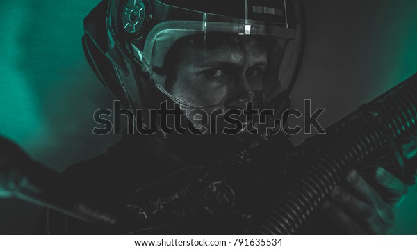 Spaceman, man\
of the future or space with futuristic helmet and fantasy lights,\
carries a laser weapon in his\
hands