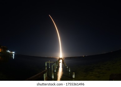 SpaceX rocket launch at night seen from Titusville, FL with destroyed dock in foreground - Powered by Shutterstock