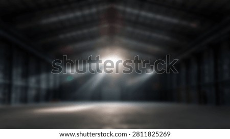 Spacious abandoned hangar featuring dramatic volumetric lighting and sunbeams piercing through a dark metal structure onto a concrete floor
