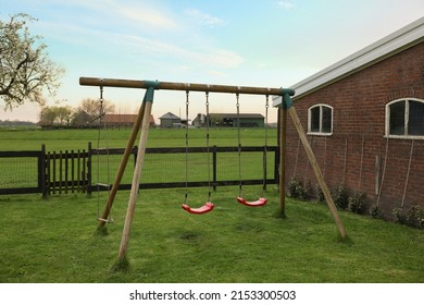 Spacious Backyard With Swing Set In Early Morning