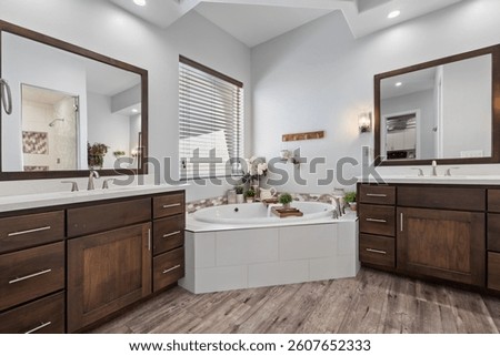 A spacious bathroom featuring two sinks, a bathtub, and two mirrors