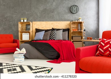 Spacious bedrooom in grey with stylish, red details