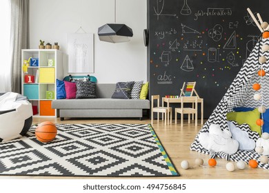 Spacious Black And White Child Room With Window, Sack Chair, Regale, Sofa, Carpet, Chalkboard Wall, Small Table, Chairs And Play Tent