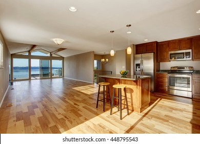 Spacious Kitchen Interior With Hardwood Floor And Beige Walls In Luxury House. 