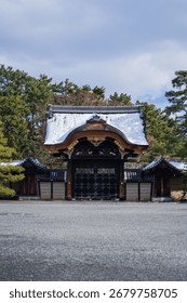 A spacious landscape featuring a lengthy structure surrounded by lush foliage and rocky formations