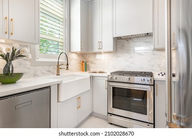 Spacious large kitchen interiors with designer cabinets stainless appliances white counter tops and eating counter - Shutterstock ID 2102028670