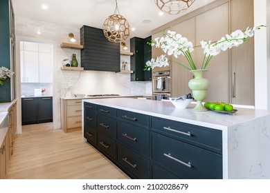 Spacious large kitchen interiors with designer cabinets stainless appliances white counter tops and eating counter - Shutterstock ID 2102028679