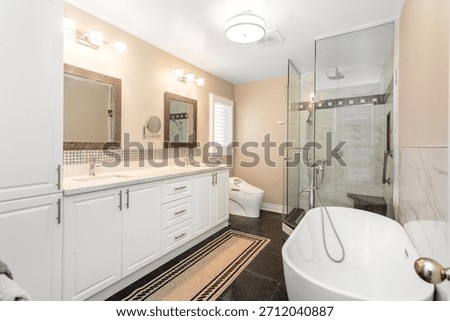 Spacious modern bathroom with double-sink vanity, freestanding tub, glass shower, elegant lighting, and clean neutral tones for a luxurious, relaxing feel.