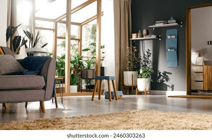 Spacious modern living room bathed in natural light, featuring stylish furniture and a variety of lush indoor plants creating a fresh, airy atmosphere. - Powered by Shutterstock