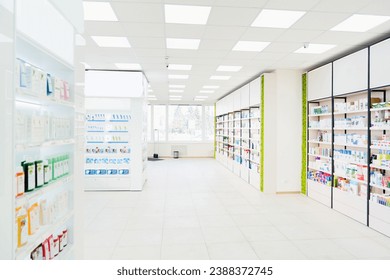 Spacious modern new white drugstore pharmacy chemist`s store with shelves full of medicines, pills, vitamins, painkillers, antibiotics without visitors - Powered by Shutterstock