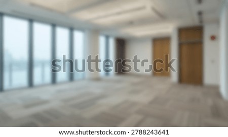 Spacious and modern office interior with large windows, offering natural light and an open floor plan. Ideal for business or commercial use.