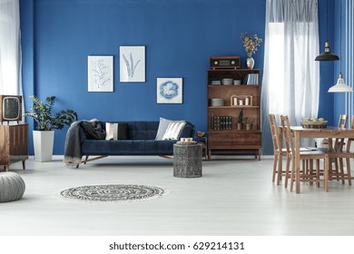 Spacious Retro Style Living Room With Blue Wall And Wooden Floor